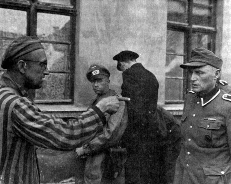 La leggendaria foto di  Harold M. Roberts. Il detenuto che indica il suo aguzzino nazista. 